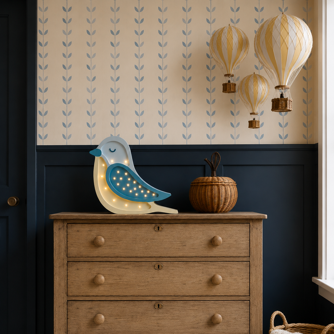 Little Lights blue and butter yellow Bird Lamp on a dresser in a baby nursery