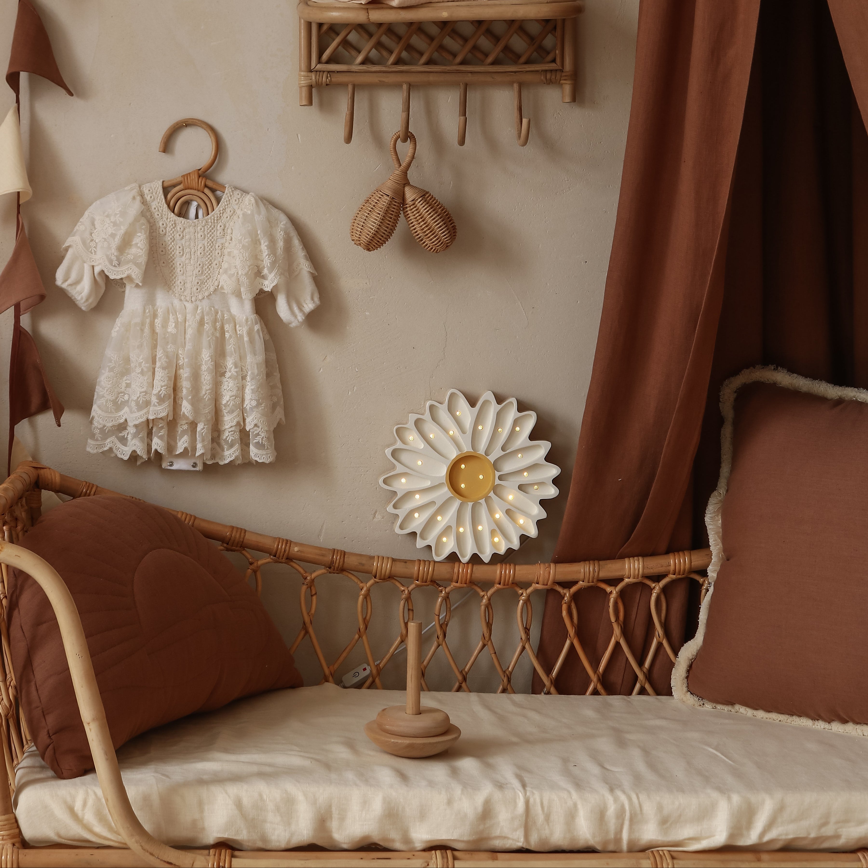 Little Lights Daisy Lamp white glowing in a kid's room next to the bed