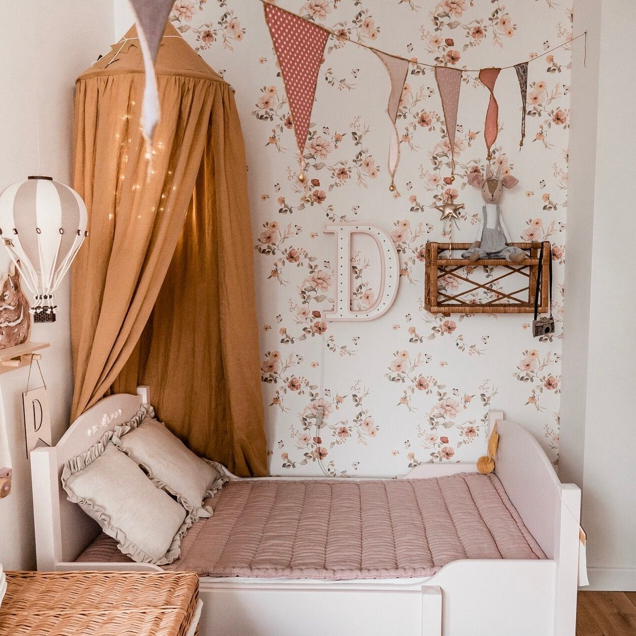 Little Lights D Letter Lamp hanging pon the wall above the bed in. a girl's room